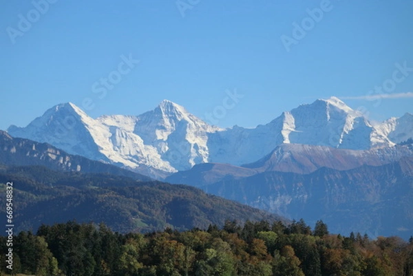 Obraz World famous mountains Eiger, Monch and Jungfrau covered with snow, blue sky in the background