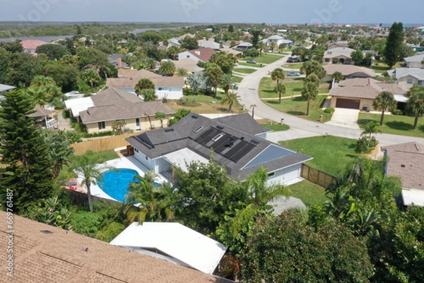 Obraz Aerial of Daytona Beach area residential neighborhood, featuring a home with an in-ground swimming pool and solar panels on the roof. 