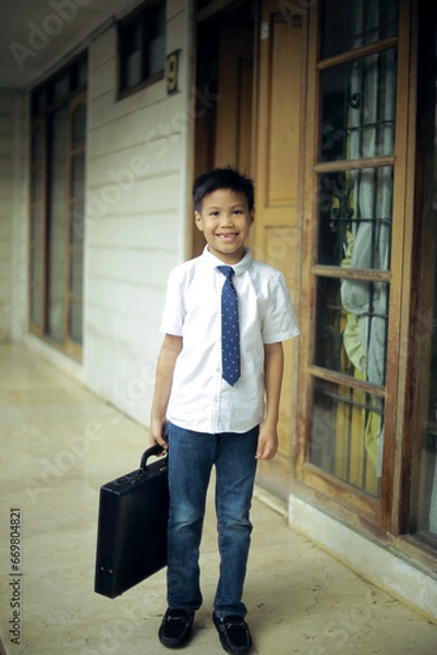 Obraz cute little boy bring suitcase acting like a businessman