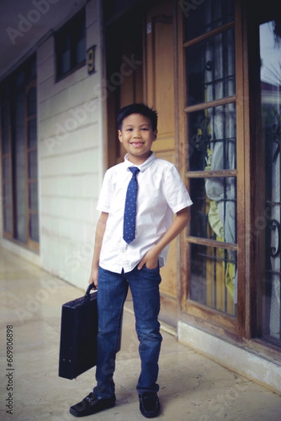 Obraz cute little boy bring suitcase acting like a businessman