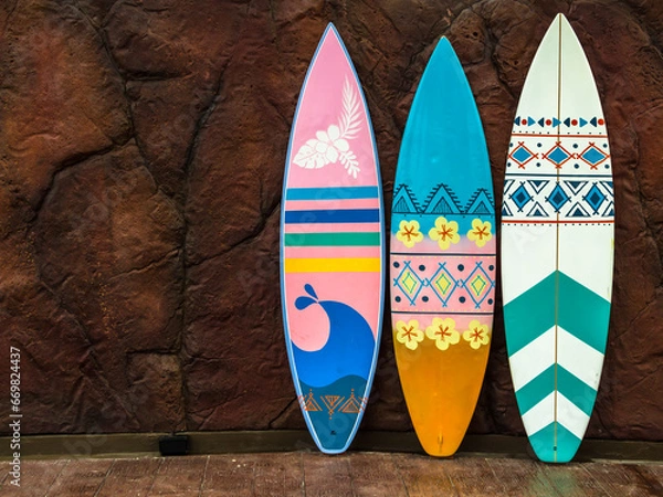 Obraz Flashy pattern surfboard against the rock wall.
