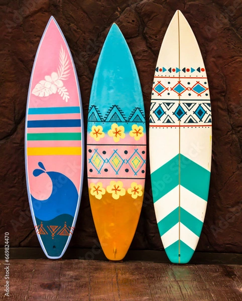 Obraz Flashy pattern surfboard against the rock wall.
