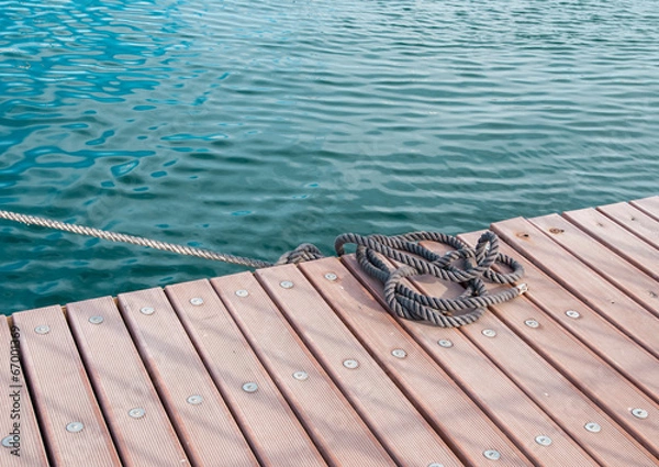 Obraz Zwinięta lina morska na drewnianym molo