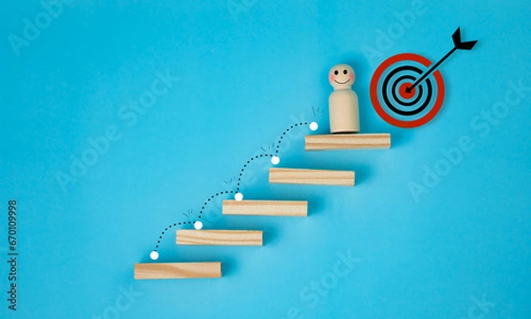 Fototapeta growth concept of business, goal oriented, successful, wooden male mannequin, standing on last step of stairs, with ultimate goal, on bright blue background, copy space.