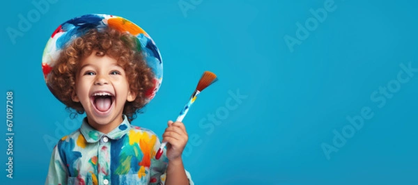 Fototapeta cute kid holding paint brush on blue color background, generative ai