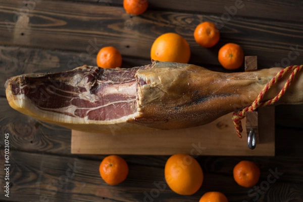 Obraz Top view of whole Serrano ham and oranges
