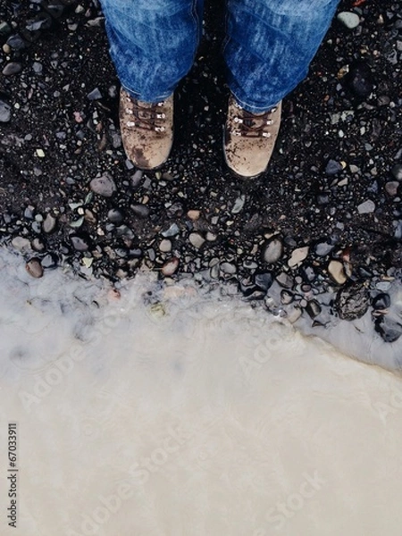 Fototapeta Hiker feet with boots in a glacier edge