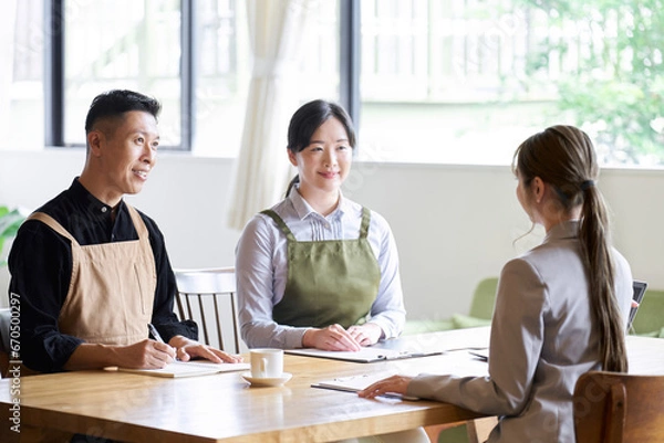 Obraz ビジネスウーマンのプレゼンを聞く飲食店の経営者
