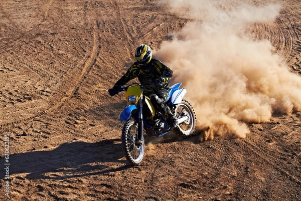 Fototapeta Man, motorcycle and bike dust cloud as professional rider in action danger competition, fearless or race. Male person, transportation or fast speed dirt adventure or rally, challenge gear or driving