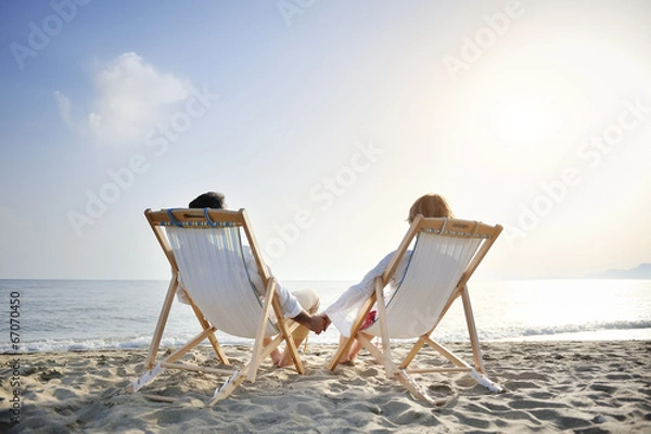 Obraz romantic couple on deckchair relaxing on the beach
