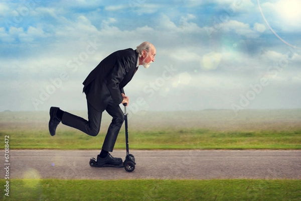 Obraz senior man riding a scooter