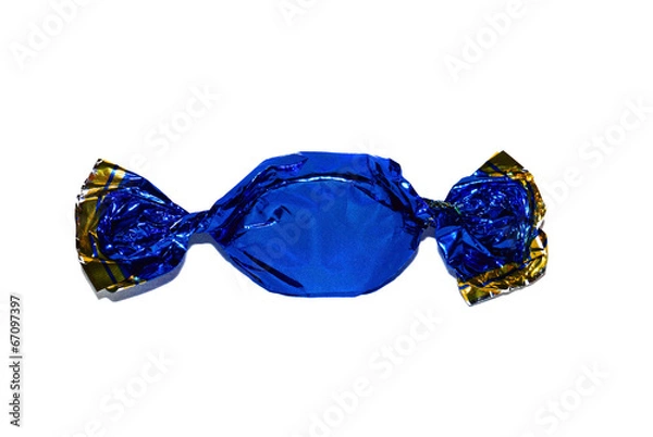 Fototapeta One candy in a dark blue shiny paper wrapper closeup