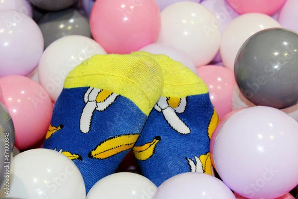 Fototapeta egs of a girl in funny blue socks with bananas in balls for a dry pool