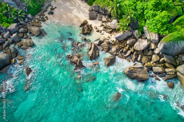 Fototapeta Bird eye drone shot of north east point beach, granite rocks, turquoise water, waves crashing, grenery, Mahe Seychelles