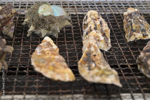 Obraz 牡蠣小屋で焼き牡蠣とサザエの壺焼きを焼いているシーン