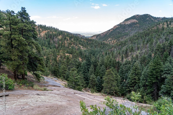 Fototapeta View from North Cheyenne Cañon Park in Colorado Springs, CO in the late afternoon on a sunny summer day, with trees, red rocks, and mountains in the landscape