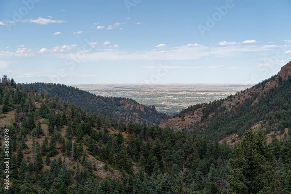 Fototapeta View from North Cheyenne Cañon Park in Colorado Springs, CO in the late afternoon on a sunny summer day, with trees, red rocks, and mountains in the landscape