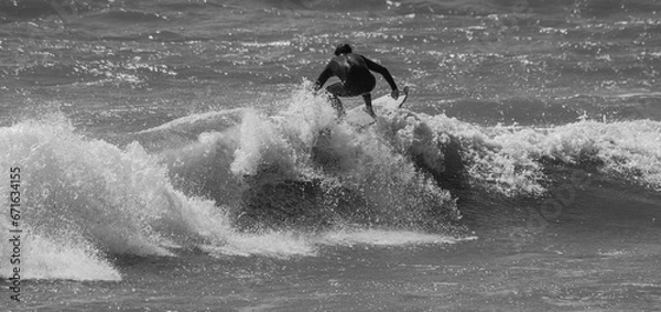 Obraz Black and white photo of a surfer on top of a wave at the spot de la sauzaie, Vendée, FRANCE.