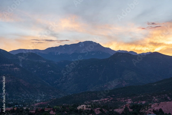 Fototapeta A colorful sunset over Pike's Peak and other blue mountains and red rocks on a fall/summer evening, as viewed from Garden of the Gods in Colorado Springs, CO