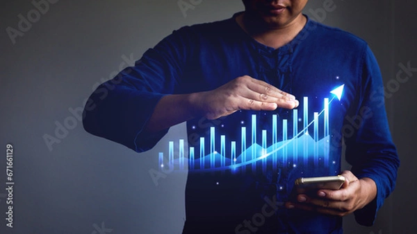 Fototapeta Businessman showing business growth graph from mobile phone display.