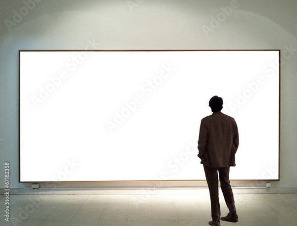 Fototapeta Man in gallery room looking at empty frames