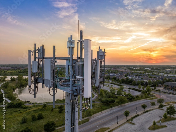 Obraz Aerial view of mobile phone cell tower by the road at sunset