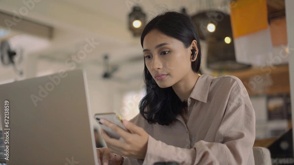 Obraz Asian freelancer cell cafe. Busy person use computer macbook coworking place. Boss woman look screen monitor. People study iphon network. Female user start up laptop desk. Coworker girl job home space