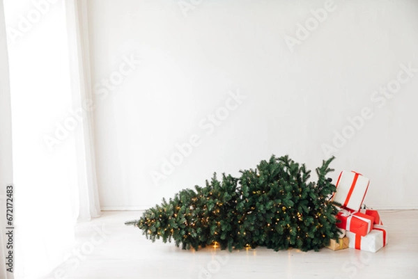 Obraz Decorated Christmas tree fallen down. Christmas gifts near fallen tree. Scandinavian Christmas tree.