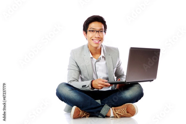 Fototapeta Happy asian man sitting on the floor with laptop