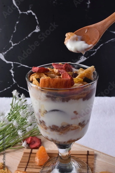 Obraz Fruitful Yogurt Medley: A delightful dessert ensemble featuring creamy yogurt paired with fresh fruits and crunchy muesli, served in a glass