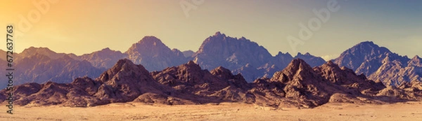 Fototapeta Panoramic landscape of mountain peaks in soft light on golden sunset time. Wide landscape with mountains in a desert, Africa.