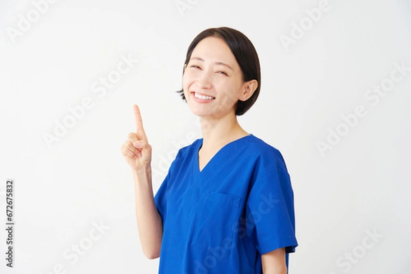 Fototapeta 左側を指差す女性の医者　白背景