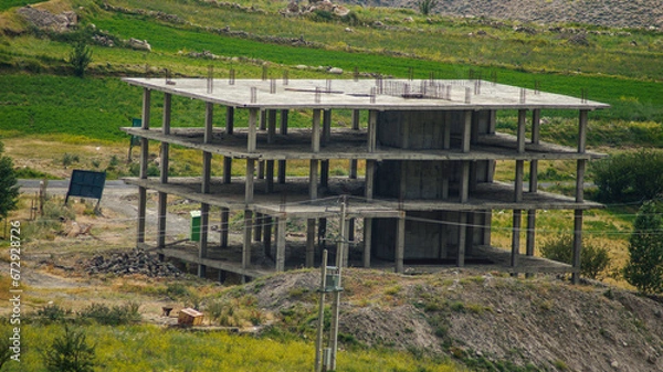 Fototapeta A multi-story building under construction in the heart of nature and in the middle of the mountains