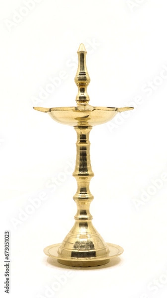 Fototapeta a unique, antique oil wick lamp or diya or vilakku made of brass used for rituals and worship as a tradition in hindu culture isolated in a white background