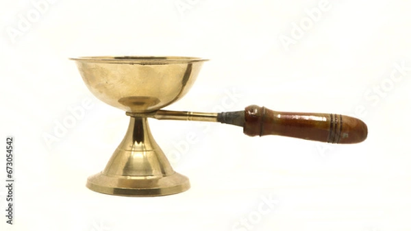 Fototapeta vintage golden brass diya oil lamp or vilakku with handle traditionally used for pooja rituals in temples of india isolated in a white background