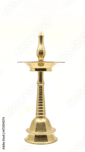 Fototapeta old vintage oil wick lamp or vilakku made of golden brass used in temples and places of worship traditionally isolated in a white background