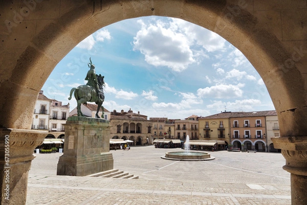 Fototapeta view of the main square of trujillo framed by an arch