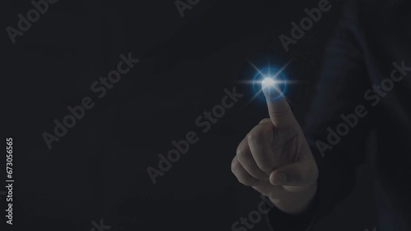 Fototapeta Businessman hand presses a glowing blue light. Concept of command with modern technology.