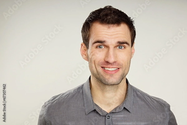 Fototapeta Portrait of a handsome smiling man at grey shirt
