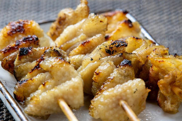 Obraz 焼鳥、皮塩串(鶏皮の塩焼き)のアップ。
