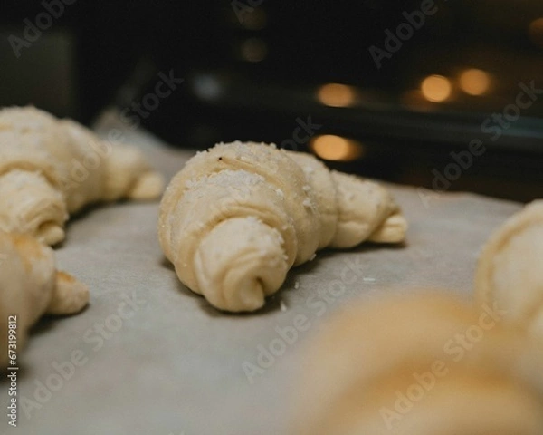 Fototapeta Closeup of raw croissant  on a baking sheet ready for baking