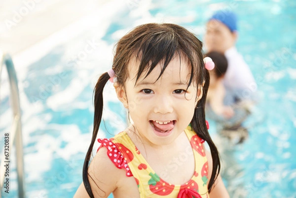 Obraz プールで遊ぶ笑顔の女の子