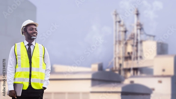 Fototapeta African engineer holding and using tablet works at factory.Engineering for large industry concepts and technological applications