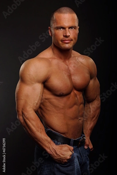 Obraz Handsome muscular man poses on gray background