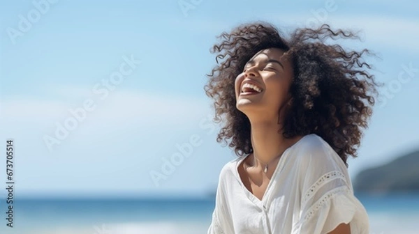 Obraz black woman on the beach and laughing at the ocean