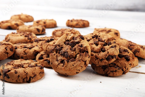 Fototapeta Chocolate cookies on white wooden table. Chocolate chip cookies on cooling rack