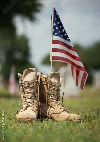 Fototapeta Old military combat boots against American flag in the background. Memorial Day or Veterans Day, sacrifice concept.