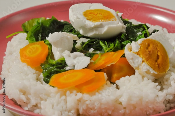 Fototapeta a menu of white rice with clear vegetables of spinach leaves and carrots and a salted egg on a wooden board isolated on a white background