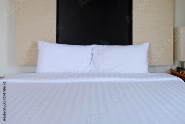 Obraz Front face of white clean arranged bed, king size, with pillows