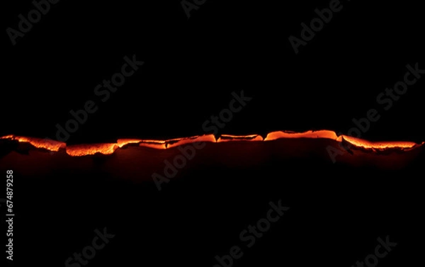 Fototapeta burning paper, glowing edge of paper on a black background